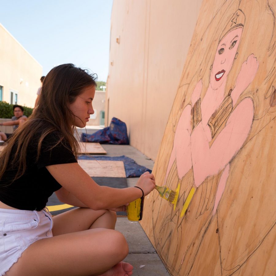 PAINTING THE UNIVERSE: Senior Ashley Peters brings a Wonder Woman decoration to life with vivid colors and bold brushstrokes in anticipation of the upcoming Homecoming dance on Oct. 5.