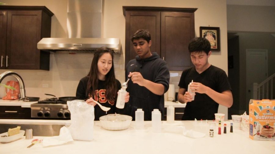 (FLOUR)ISHING ARTISTS: Juniors Erin Kim, Varun Vishnubhotla, and Anlon Zhu (left to right) fill squirt bottles with colored pancake batter.