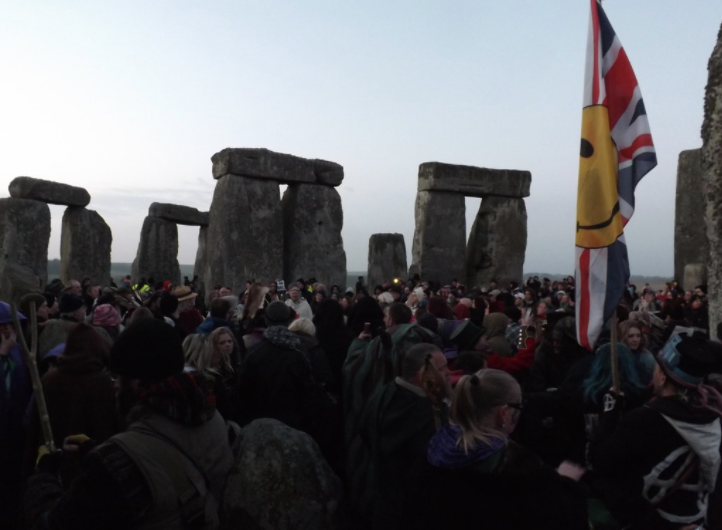 A mix of attendees in robes and casual wear gathering at Stonehenge on the 2015 March equinox.