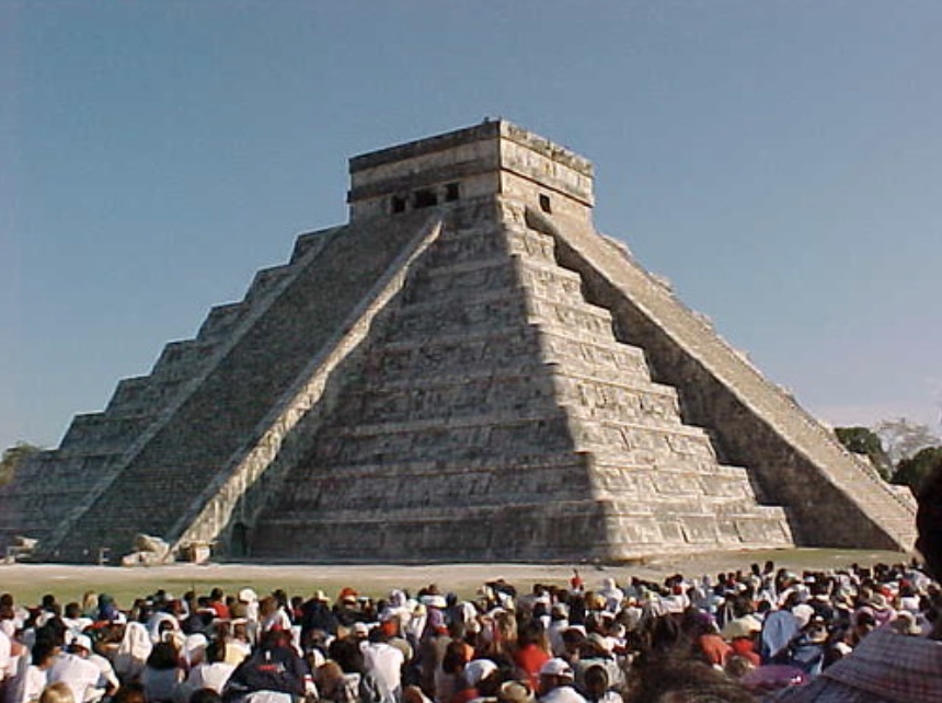 The Chichen Itza pyramid in the late afternoon, with a crowd watching the serpent shadow illusion.