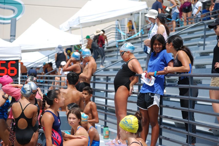 CONSTRUCTIVE COACHING: Senior Simran Patel offers helpful advice and support to a swimmer before her race.
