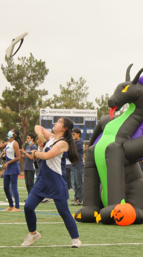 OUTSIDE OR INSIDE, NO MATTER: Color Guard captain junior Sydney Huang performs in the rally confidently on her home turf.