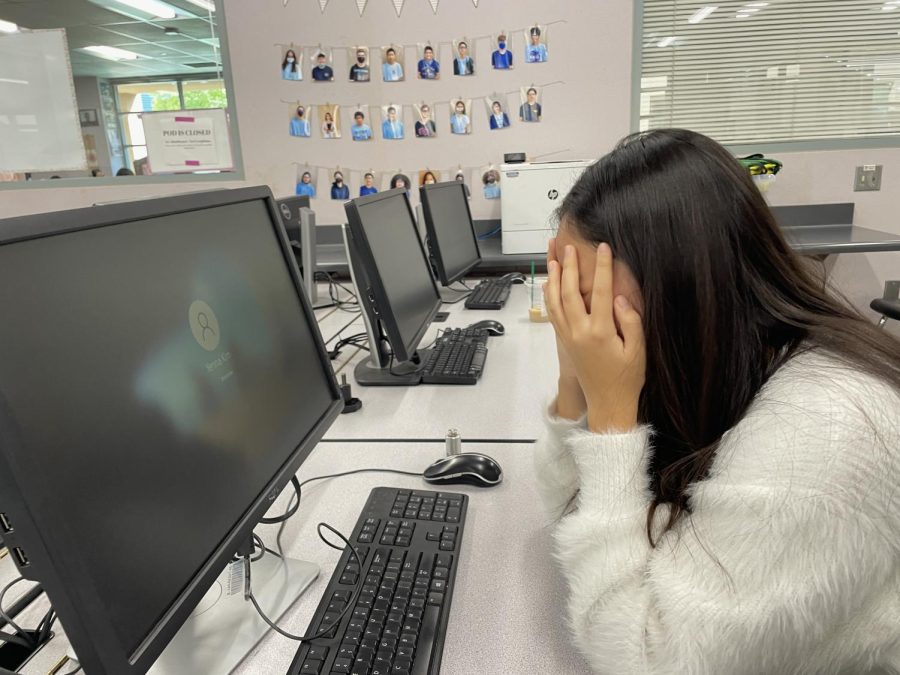 COMPUTER COMPLAINTS: Senior Yenna Kim grows weary and old waiting to print her Huckleberry Finn essay. 