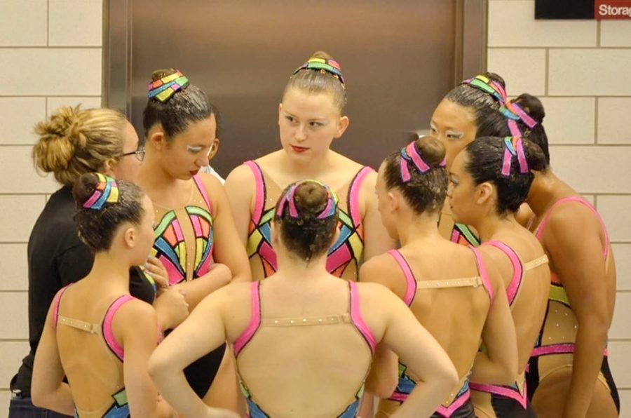 PERFORMANCE PREPARATION: Senior Amanda Carlson (top right) listens attentively to her coach before a team competition.