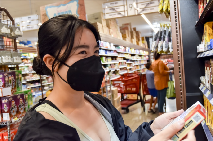 CARTING TO H-MART: Senior Sydney Hoang browses the endless flavors of Pocky at the newly opened H-Mart in Westpark Plaza.