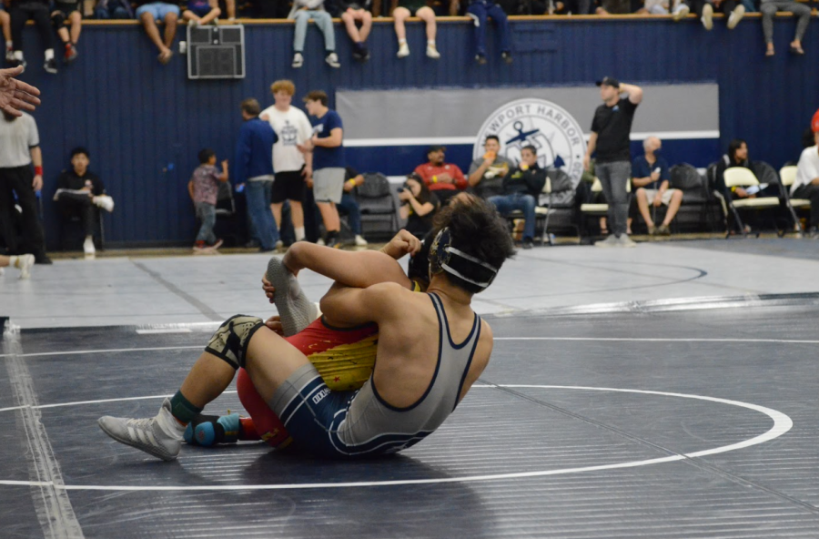 COUNT THE PINS: Senior Aiden Tak holds his opponent during a match at the Lancer Open.