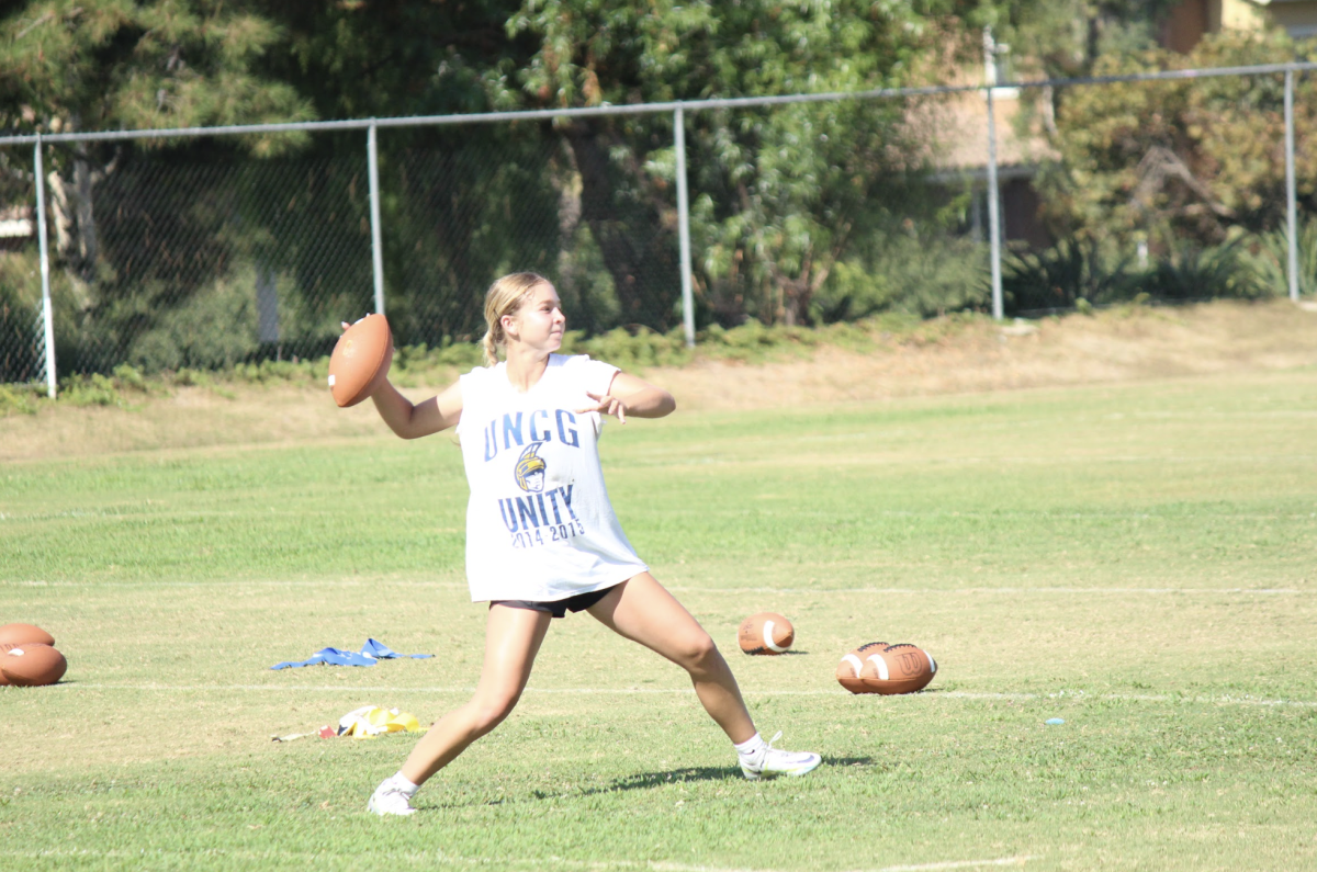 HANDOFF: Senior Lauren Silva lines up to throw the football during the summer Flag Football camp.