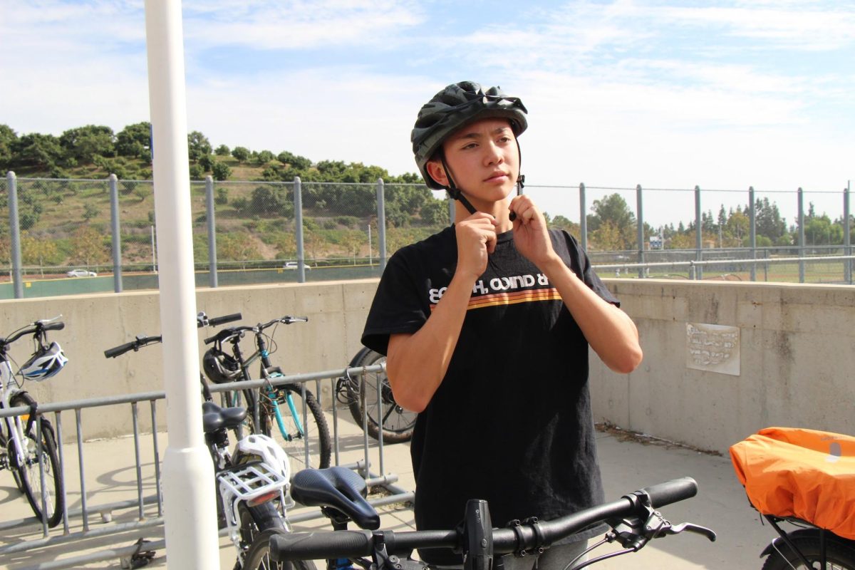  LAW-A-RIDING: Freshman Max Haymes gets ready to bike home safely by putting his helmet on properly.