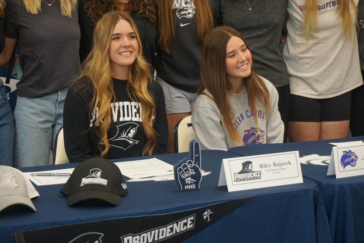 SIGNING OFF: Ava Giglio and Riley Bajorek sign their commitment letters to West Carolina University and Providence College, respectively.