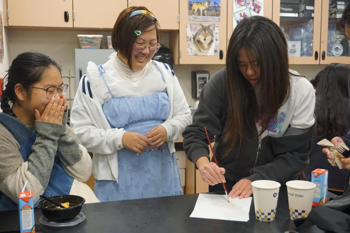 ENTERTAINING LUNCHTIME EXPERIMENTS: board member senior Mina Sun demonstrates how to use invisible ink to her peers
