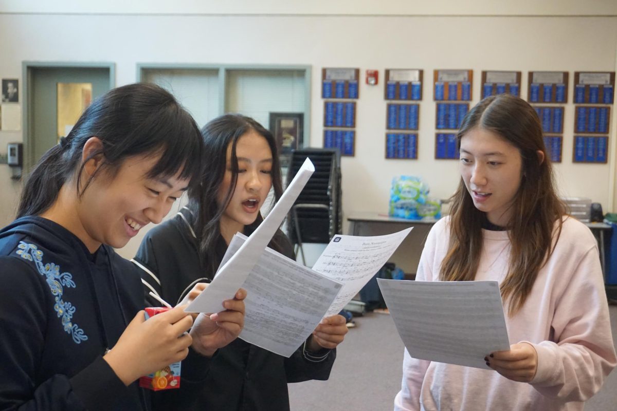 LUNCHTIME MELODIES: Junior Chen Yang and senior Leyna Doan practice the alto part for “Bare Necessities” at Acapella Club.
