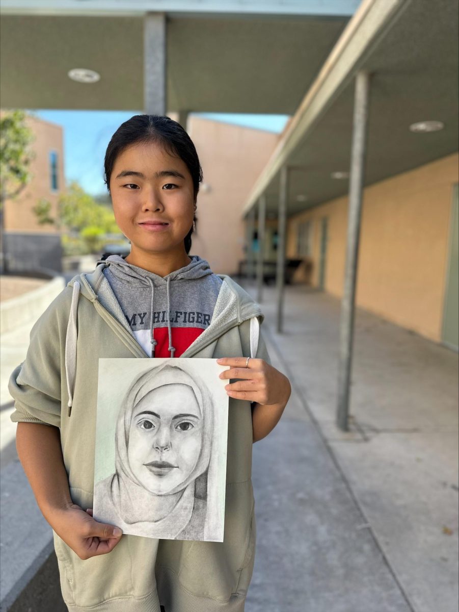PORTRAIT OF JOY: Freshman Jiyoung Yun created a char- coal portrait for Malak, a Syrian girl who enjoys writing stories. Photo provided by Kim Rohrs