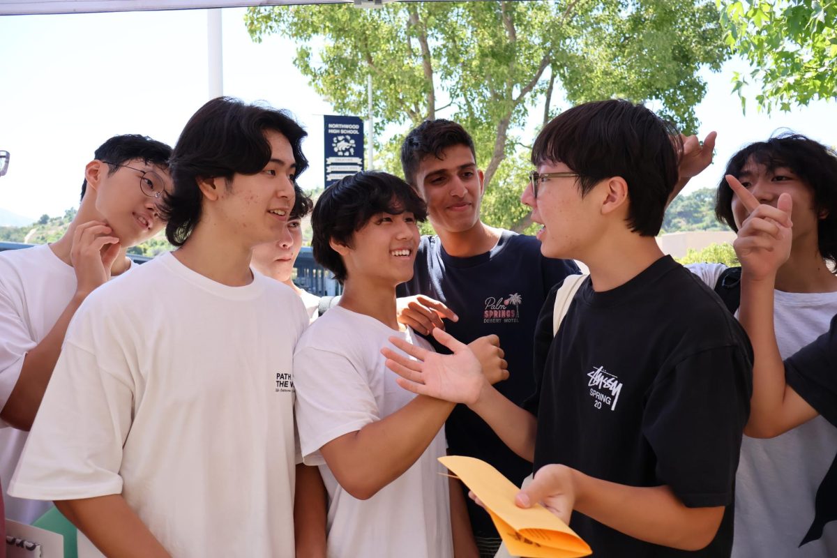 ThE PACK IS BACK: (From left to right) Sophomores Cole Kuang, Ian Moon, Arsh Verna and Ryan Koo catch up on their summer stories while waiting in line for Kick-Off Day.