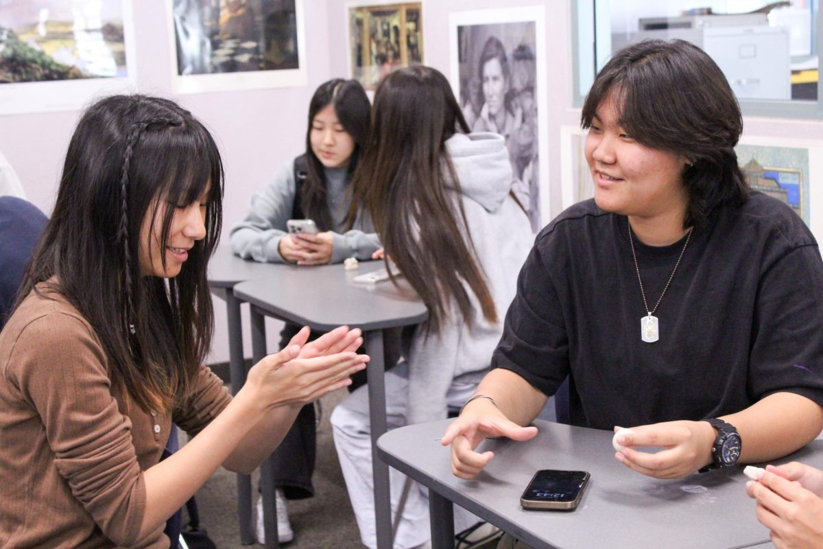 CLAY CREATIONS: Senior Yvonne Lee and junior Sage Park create clay figures at Art History Club’s first meeting of the year.