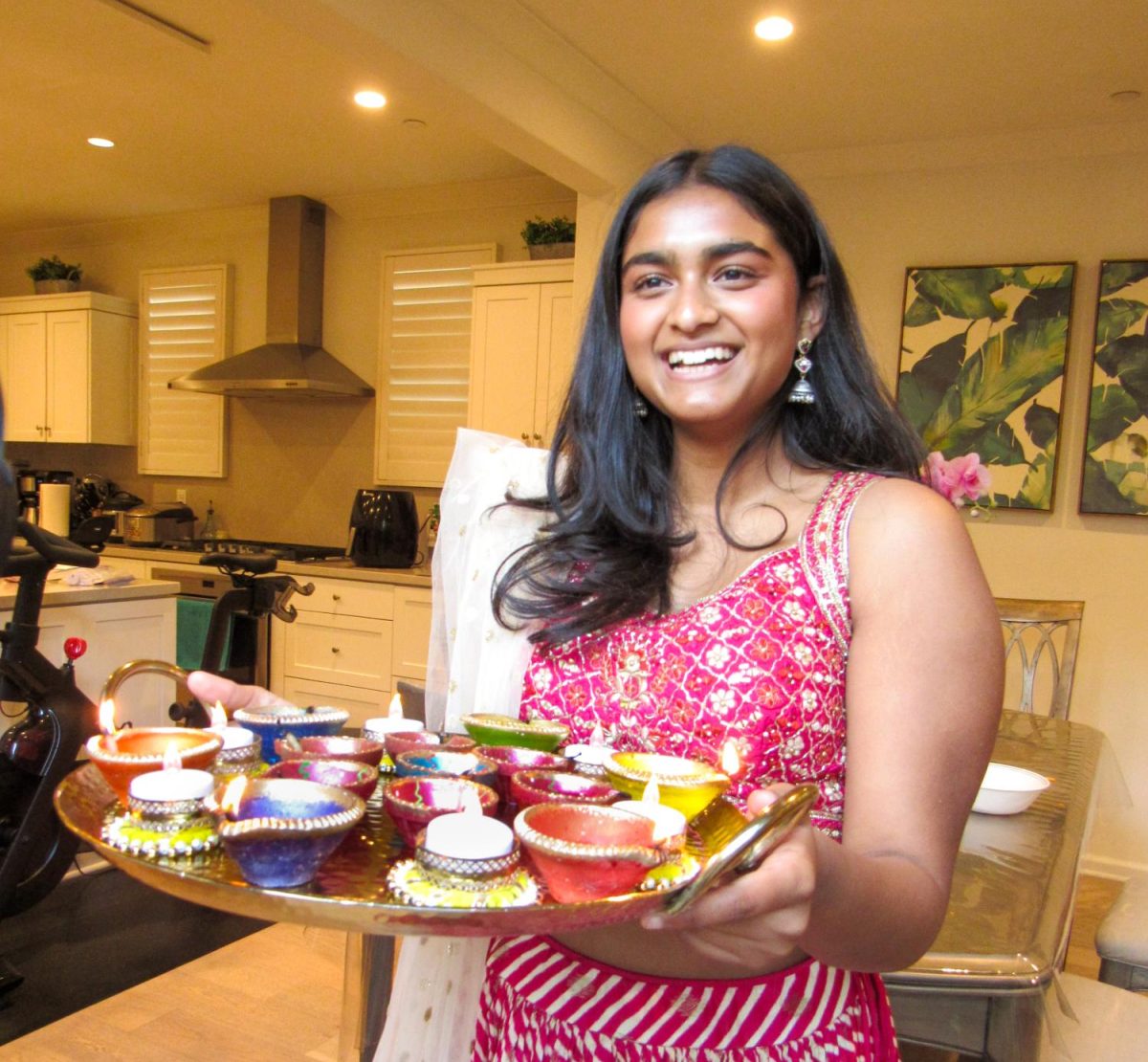 CONNECTING THROUGH CULTURE AND COMMUNITY: Senior Malaika Mateti holds a tray of candles in her traditional South Asian attire while celebrating Diwali with her friends. 