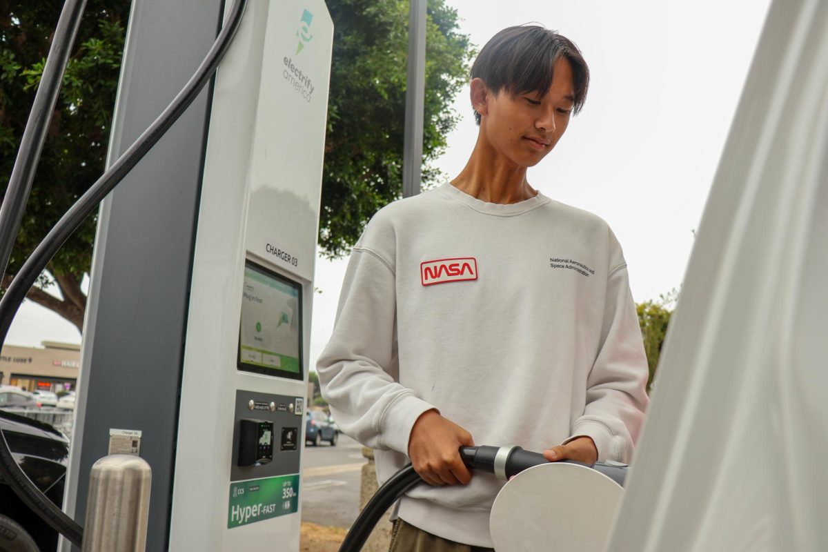 CHARGING ON THE GO: Senior Jimmy Chen charges up at Northwood Town Center.