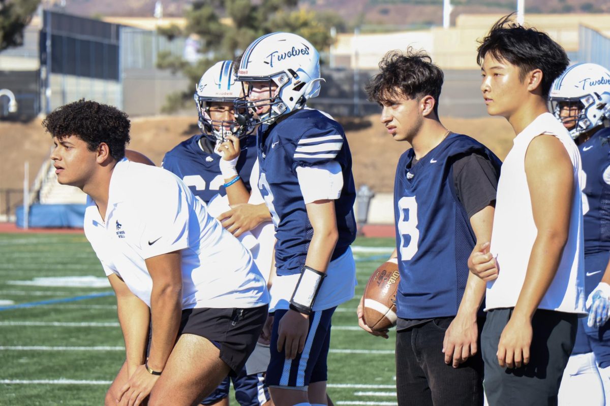 FROM PLAYER TO COACH: JV coach and former Northwood football player Danial Kamel (Class of 2023) observes the home game against Aliso Niguel High School, guiding his JV squad with the same passion he once brought to the field as a player