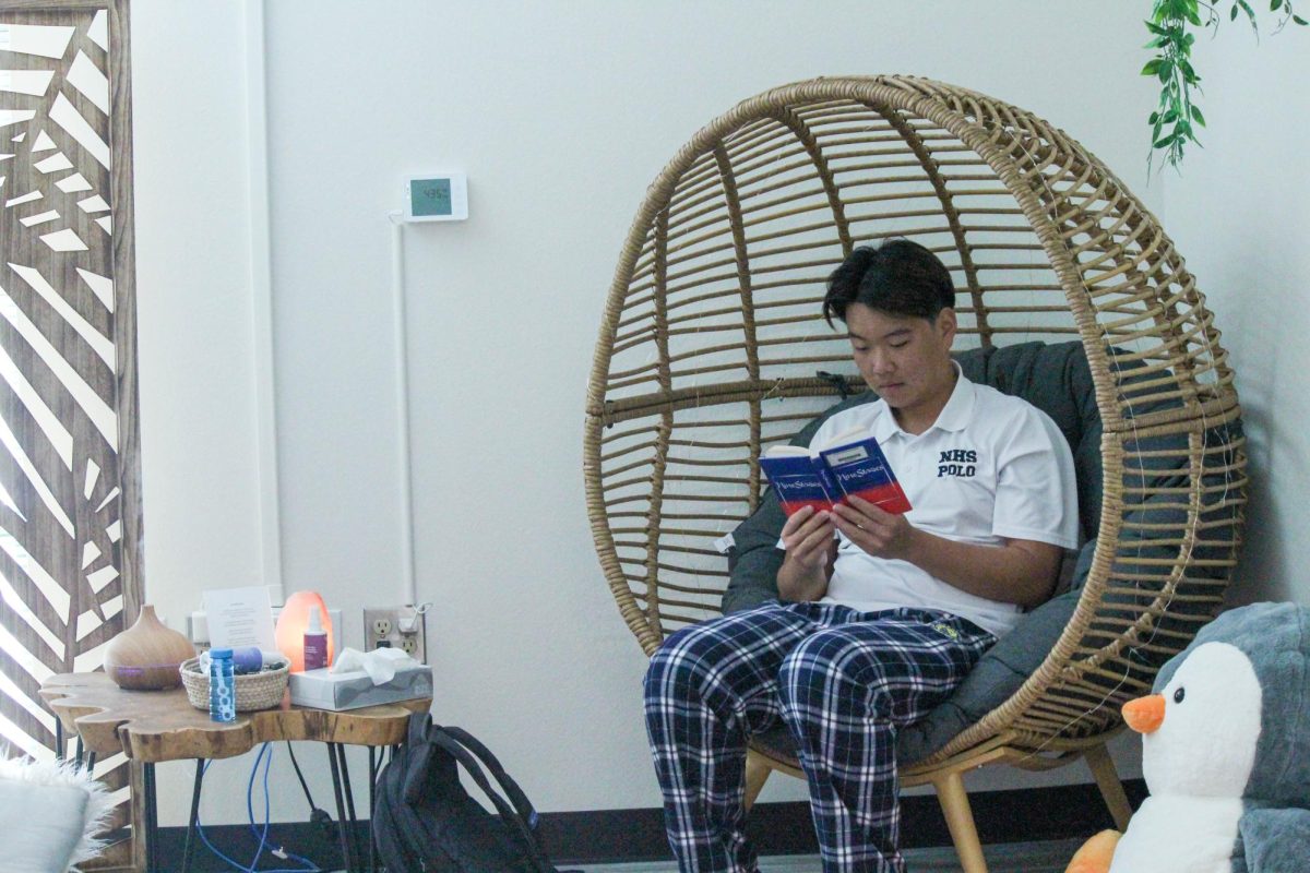 FRESH NEW LOOK: Senior Larry Lee destresses by reading a book and relaxing in the corner of the newly renovated Well.