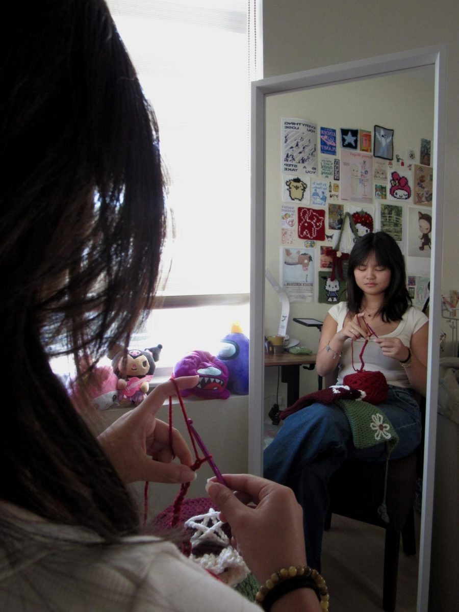 STAY IN THE LOOP: Senior Valentina Nguyen works on intently her next crochet piece, a red hat, which she is making as a commission from her Instagram account @valentinacrochets