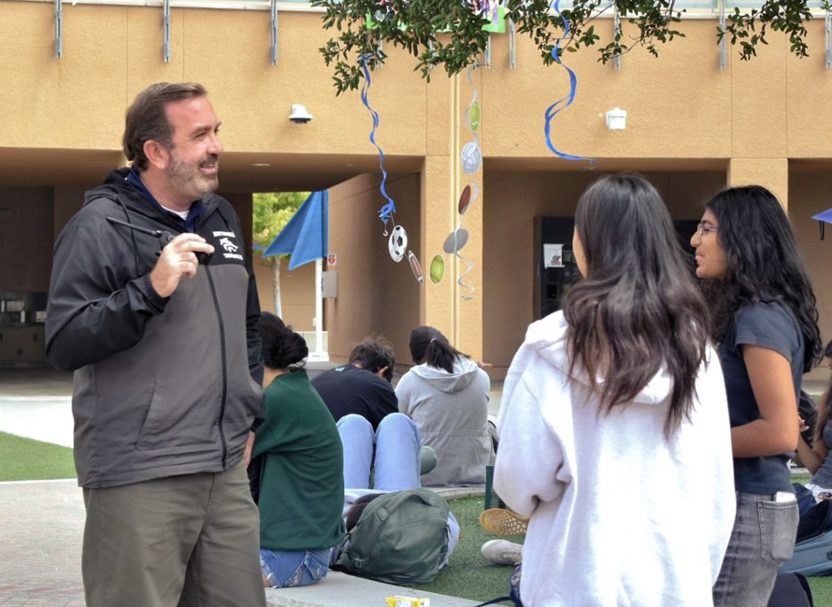 FUN WITH FACULTY: Assistant principal Eric Keith converses with sophomores Trisha Kolur and Grace Li during Advisement, discussing school life and weekend plans.