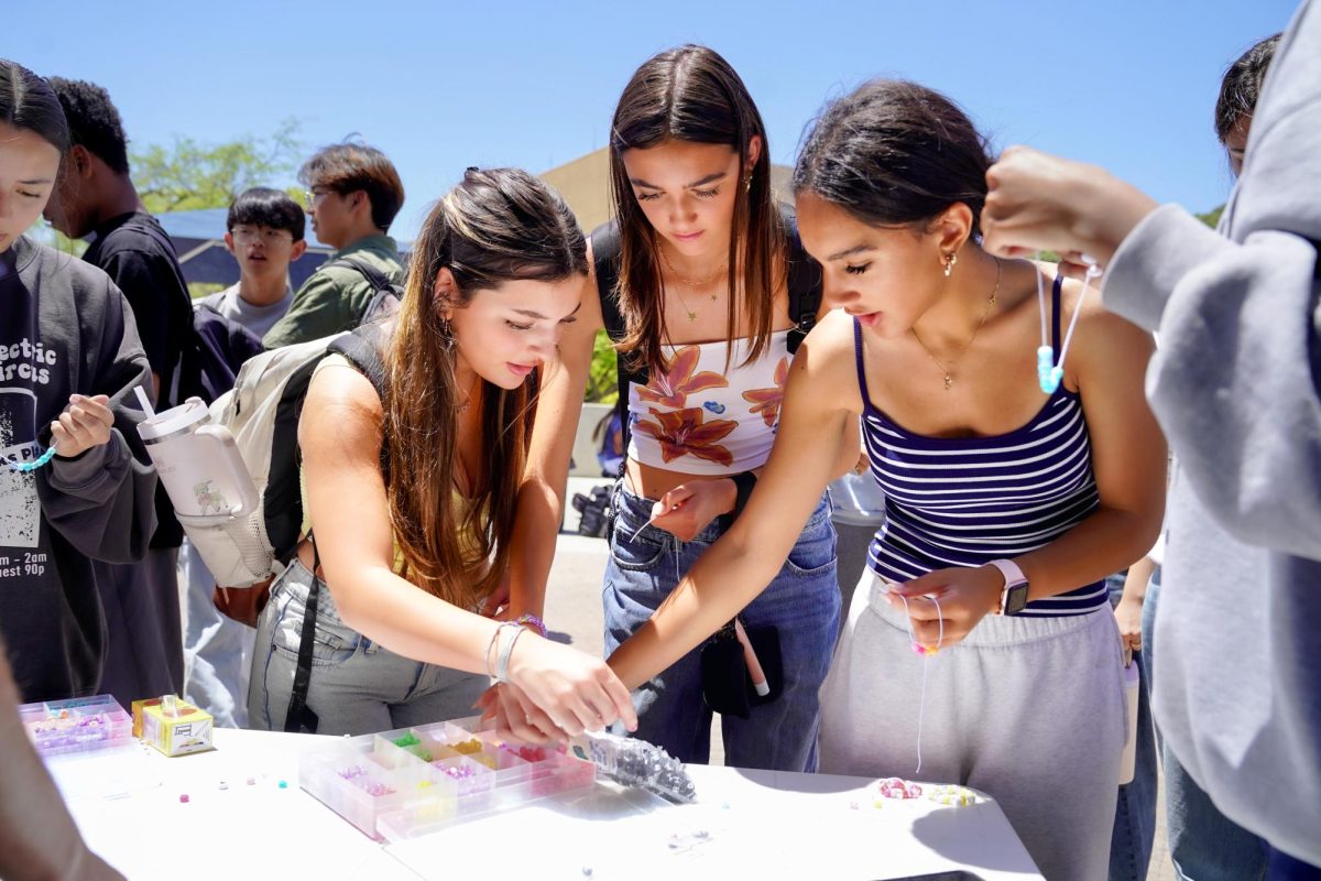 BEADED BRACELETS: In honor of the Distinguished Timberwolves ceremony, freshman Jules Martin, freshman Becca Short, and junior Kenzy Imam make friendship bracelets to celebrate connection.