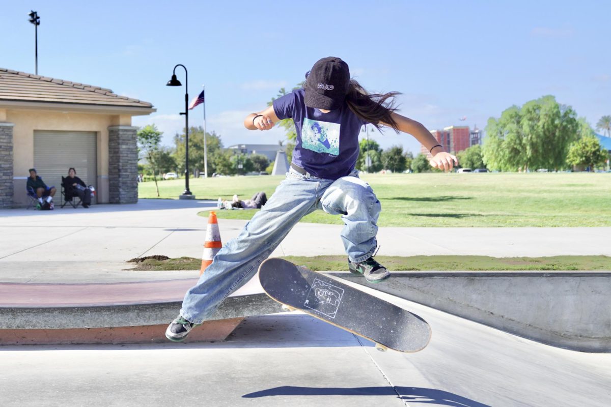 UP IN THE CL-AIR-E: Junior Claire Lin pulls off a kickflip at Tustin Legacy Skatepark, displaying her skateboard’s design midair. Her customized skateboards are a defining characteristic to identify her midair as she glides up the ramp.