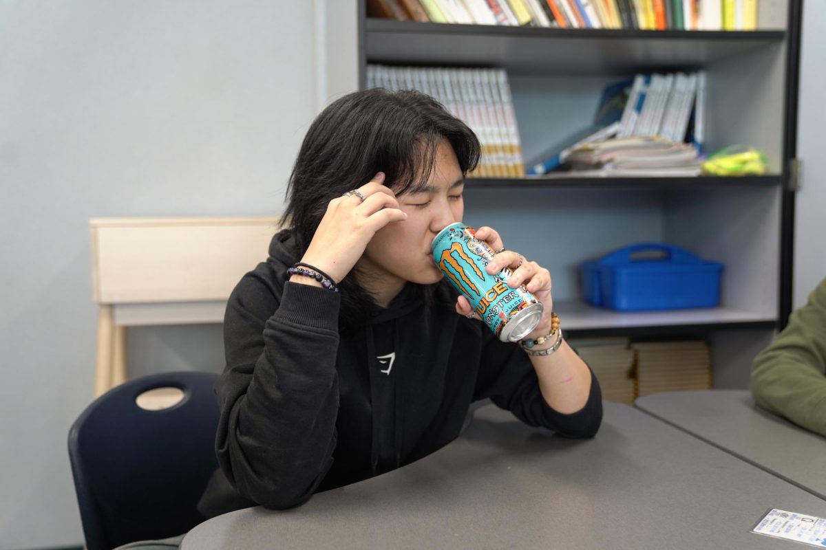 CAFFEINE CRAZE: Junior Sophia Chen enjoys a Monster Energy drink to stay alert during class.