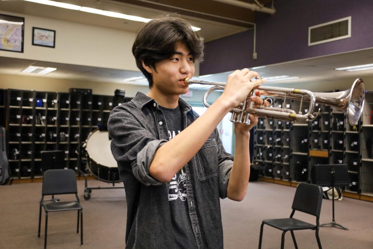TRUMPETING TO NEW HEIGHTS: Senior Sooho Cho practices his new composition piece on the trumpet, care-
fully experimenting with different chord progressions and musical phrases as he listens for places to improve the score.